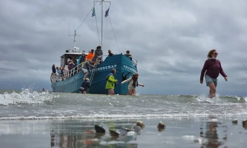 de deelnemers gaan via de trap vanaf het schip