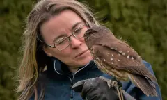 Bezoeker met vogel op arm