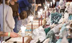 Beursfoto met bezoekers bij een stand met mineralen.